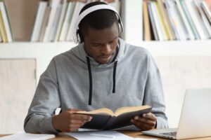 Man on headset reading a book